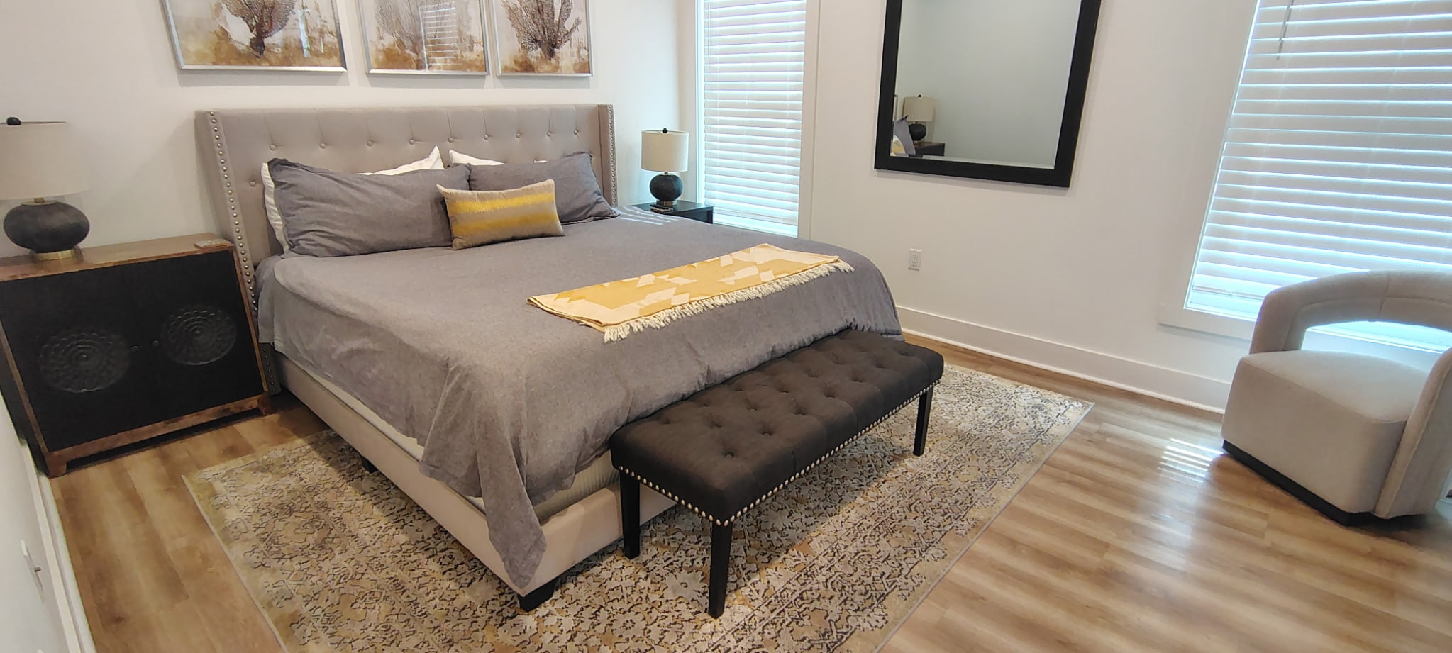 Clean bedroom with white bedframe and yellow accent pillows